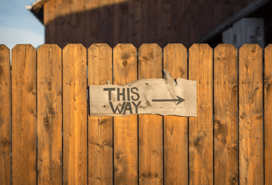 wooden fence with this way sign
